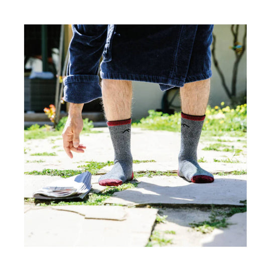 Gray crew socks with red cuffs and toes worn with rolled denim shorts