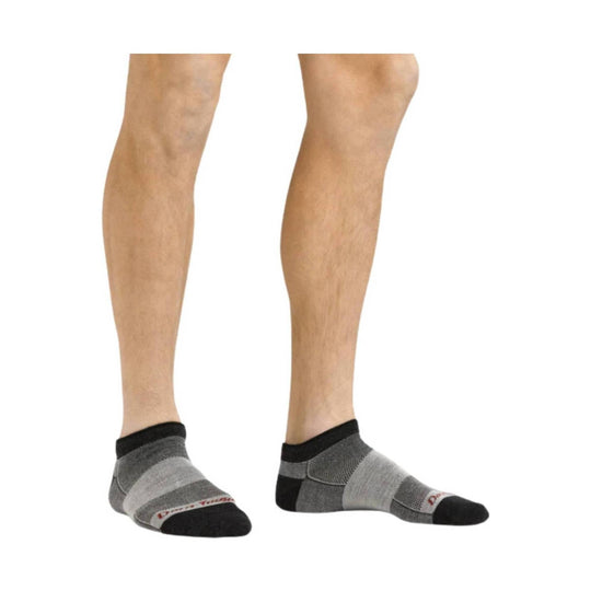 Pair of low-cut gray running socks with black toes and heels, shown on a model's lower legs