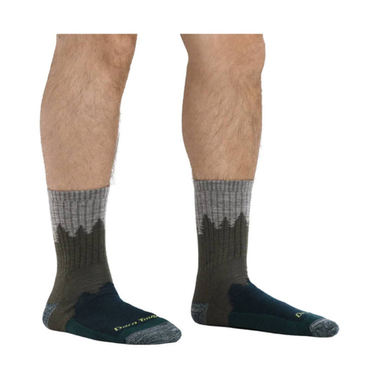 Pair of dark hiking socks with gray patterned cuffs and toe caps, worn on lower legs