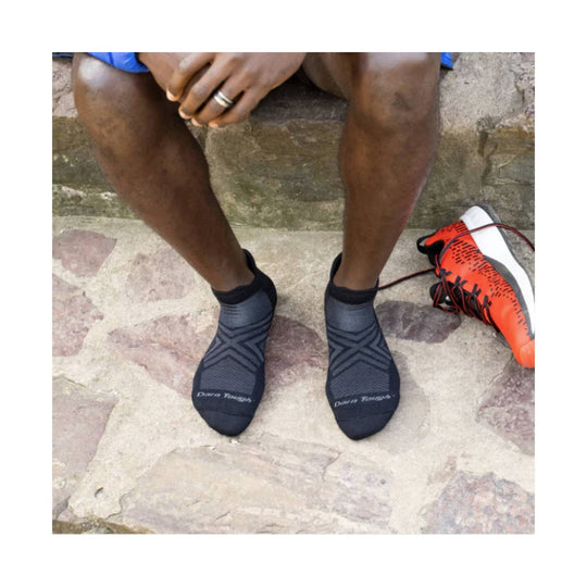 Black no-show running socks worn with the brand name visible on the toes
