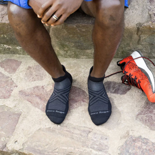 Black ankle running socks with geometric knit pattern and visible Darn Tough text