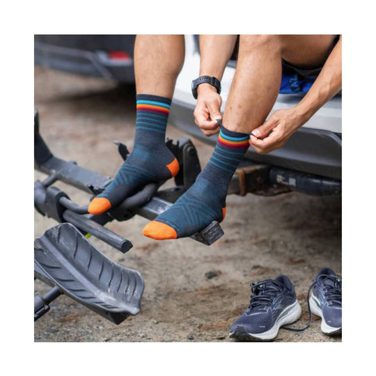Navy running socks with rainbow stripes and bright orange toes and heels being put on