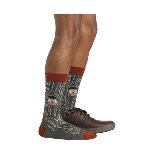 Dark gray crew socks with rust cuffs, heels, and toes, featuring a woodland face pattern, worn with brown dress shoes.