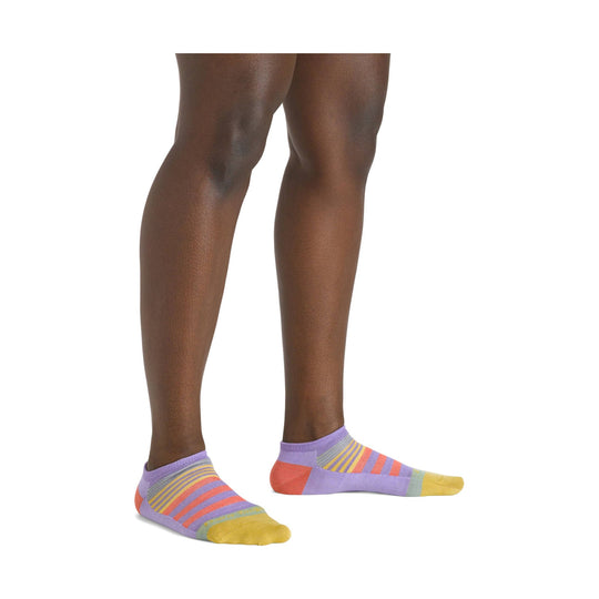 Lavender no-show ankle socks with multicolor stripes and yellow toes on a model’s feet