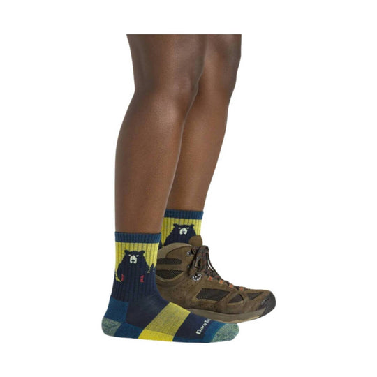 Blue and yellow bear-patterned crew socks worn with a brown hiking boot
