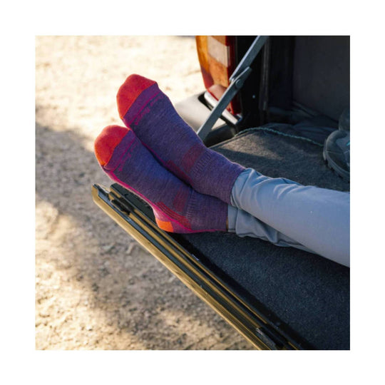 Pair of purple and pink quarter hiking socks worn with light gray pants