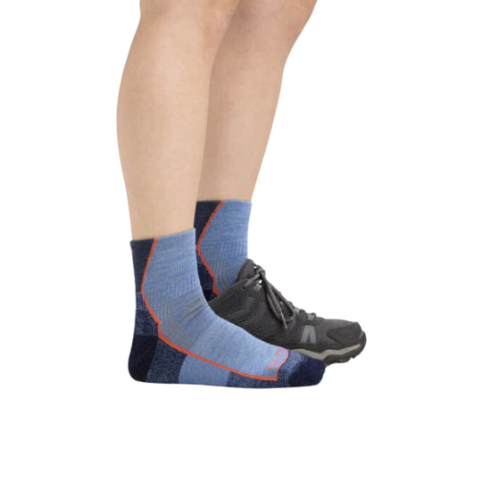 Light blue and navy quarter hiking socks with orange trim worn with black trail shoes