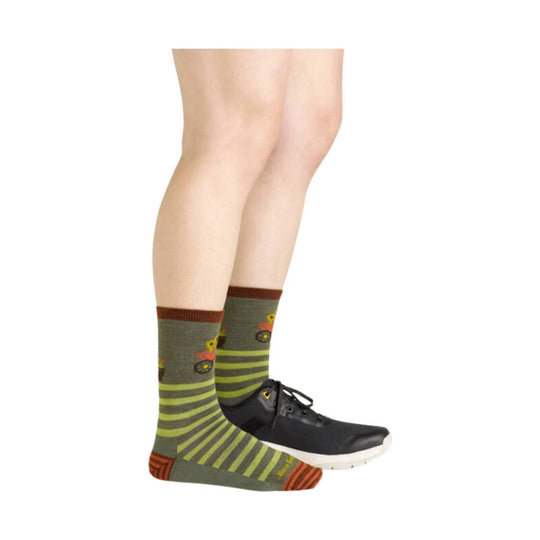 Olive crew socks with lime stripes, brown accents, and colorful animal-and-vehicle pattern, shown with black sneaker