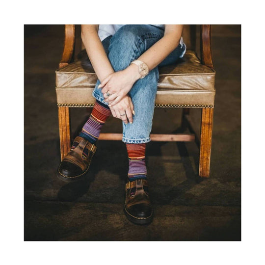 Striped crew socks in purple, red, and blue worn with brown leather sandals
