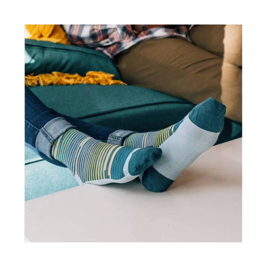 Striped crew socks in teal, green, and white worn with rolled jeans