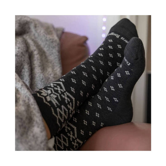 Black patterned crew socks with white geometric motifs and Darn Tough logo on the cuff