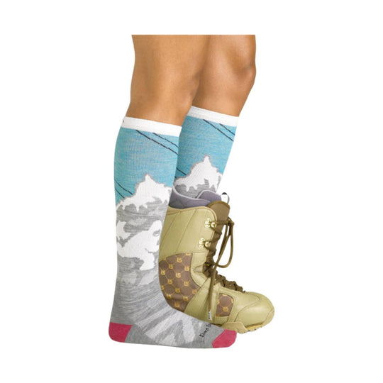 Over-the-calf ski socks in blue, gray, and pink with mountain graphics, shown with a boot