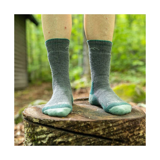 Gray midweight hiking socks with teal toe and heel accents worn outdoors on a tree stump