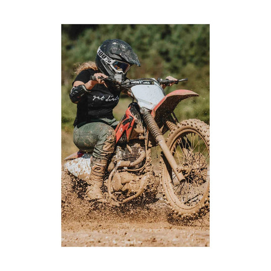 Mud-covered olive green work pants worn while riding a dirt bike