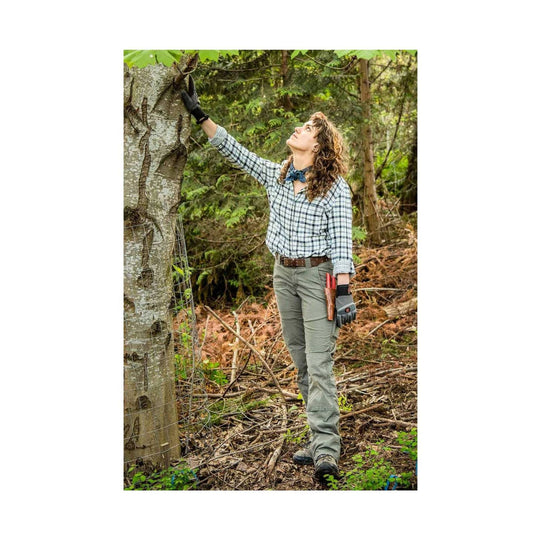 Olive green straight-leg outdoor pants worn with a belt, shown on a model in the woods