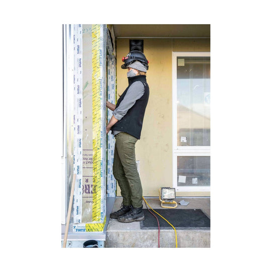 Olive green work pants worn by a side-view construction worker