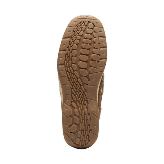 Tan shoe outsole with oval traction pods and curved tread pattern
