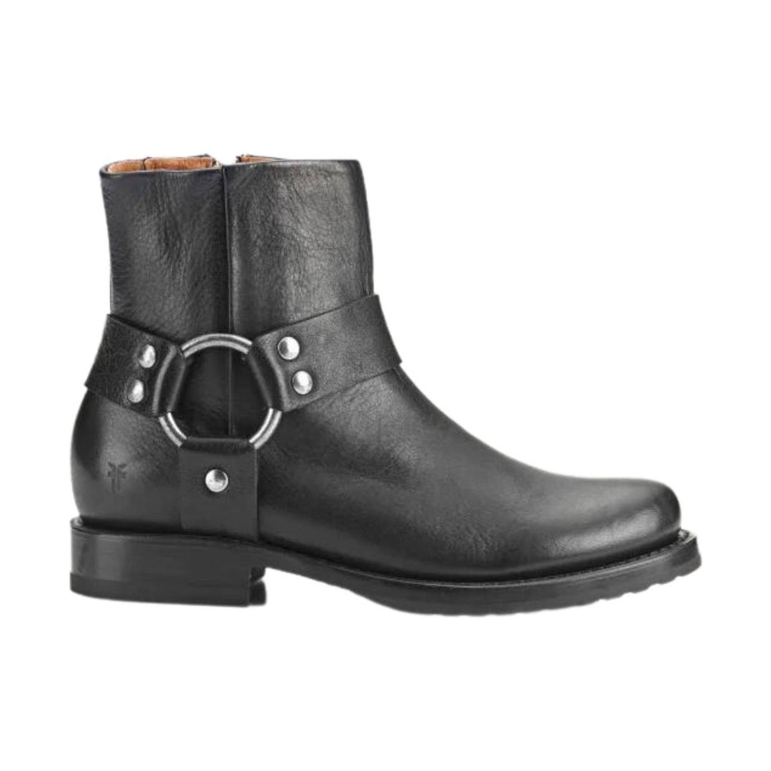 Black ankle boot with harness strap, silver ring detail, and low block heel