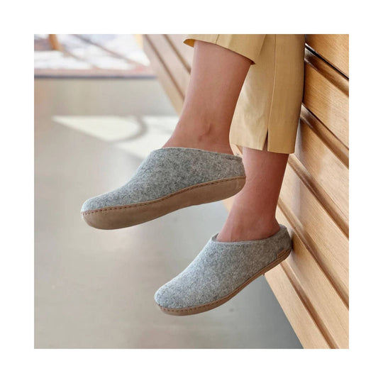Gray felt slip-on slippers with tan leather soles, worn with cropped beige pants