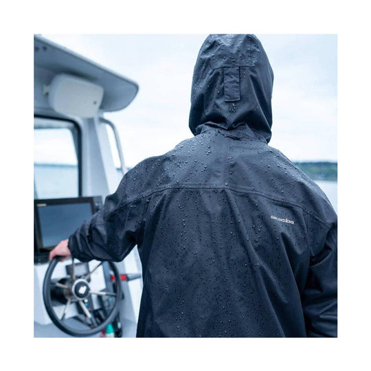 Black hooded rain jacket seen from the back on a boat, with water droplets on the fabric