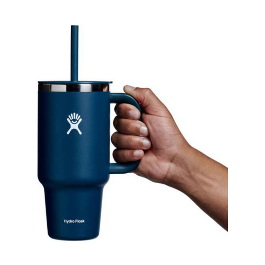 Blue insulated travel tumbler with handle and straw, shown with a hand holding it