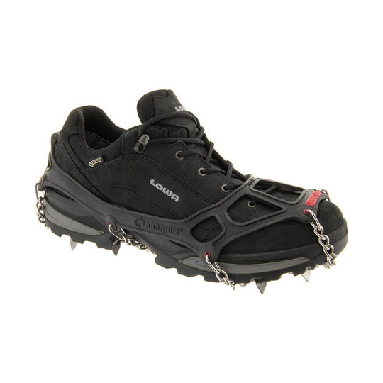 Black hiking shoe with traction spikes and chains, shown in side view