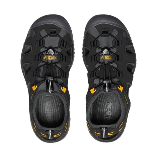 Black closed-toe hiking sandals with bungee lacing, side cutouts, and yellow accents