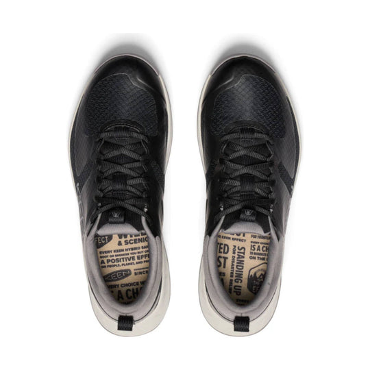Top view of black lace-up athletic shoes with white midsoles and printed tan insoles.