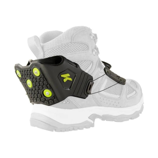 Black traction cleat with lime accents attached to a white hiking boot