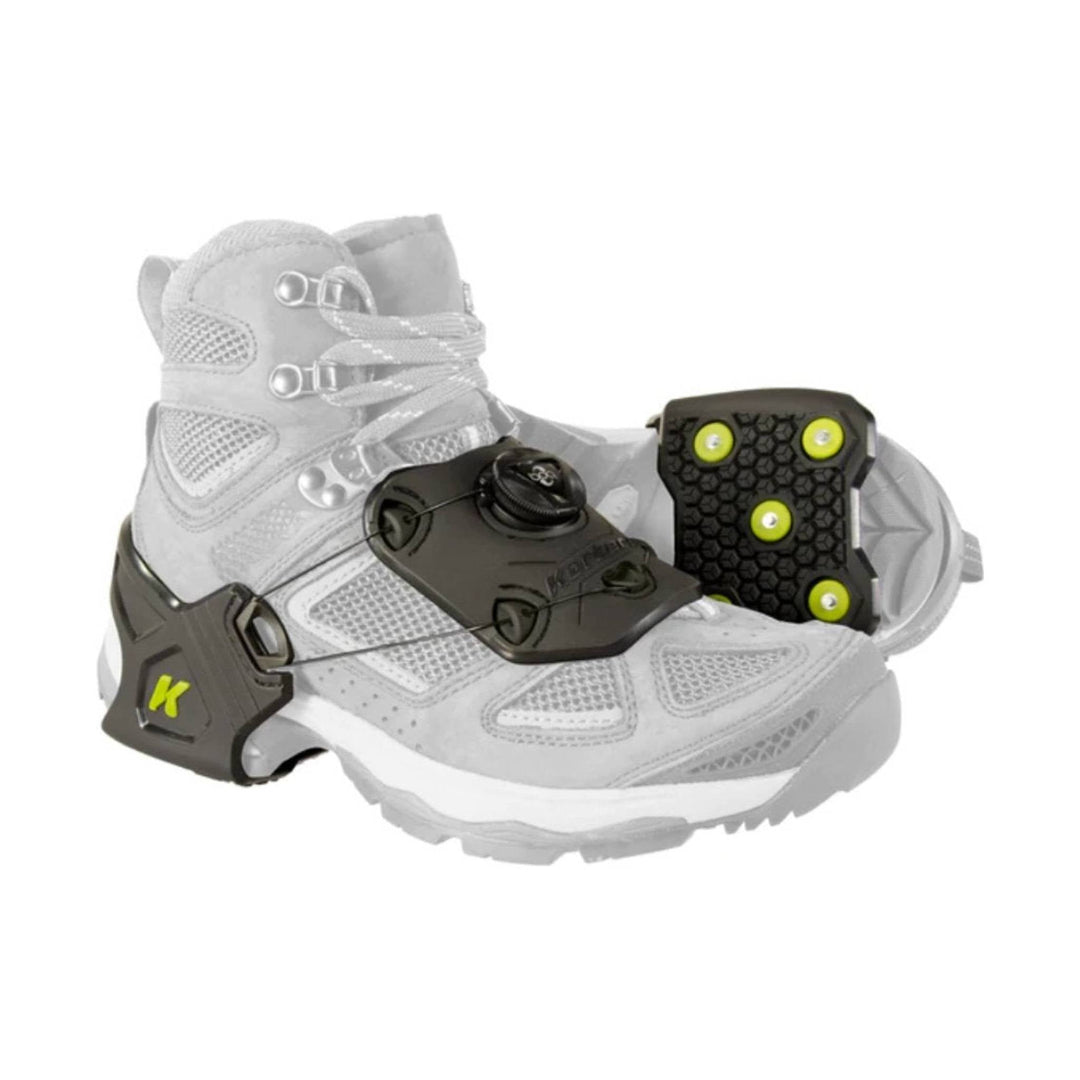 White winter boot with black traction cleats and yellow accents
