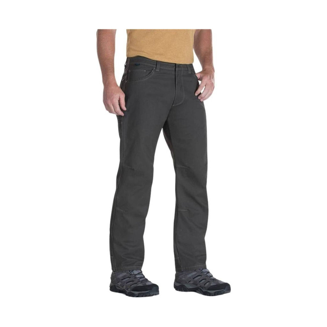 Dark gray men’s hiking pants shown on a standing model with cargo-style side pocket and outdoor shoes