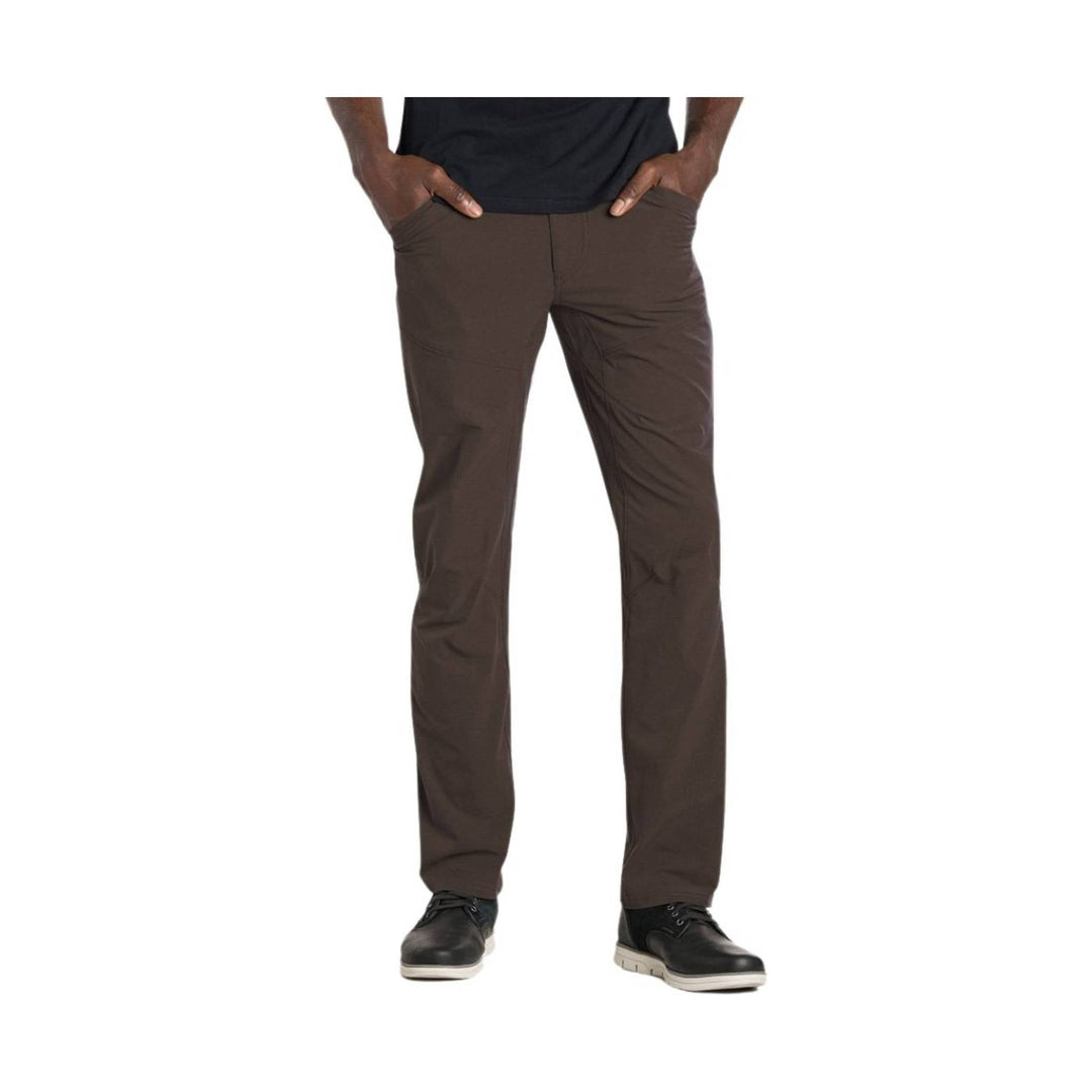 Brown straight-leg men’s pants with front pockets, shown on a model with hands in pockets