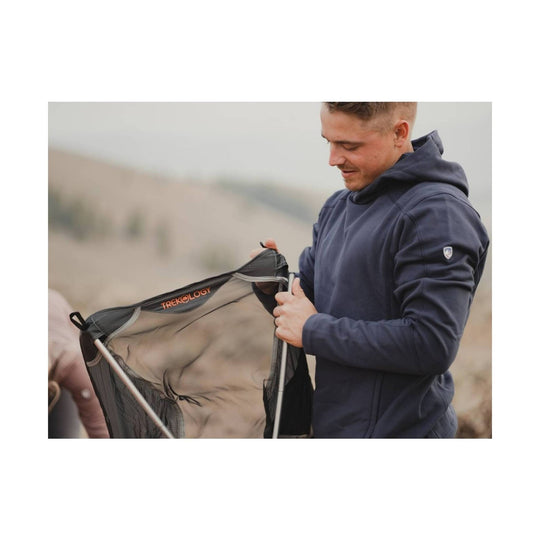 Man wearing a navy hooded sweatshirt while holding a portable camping chair