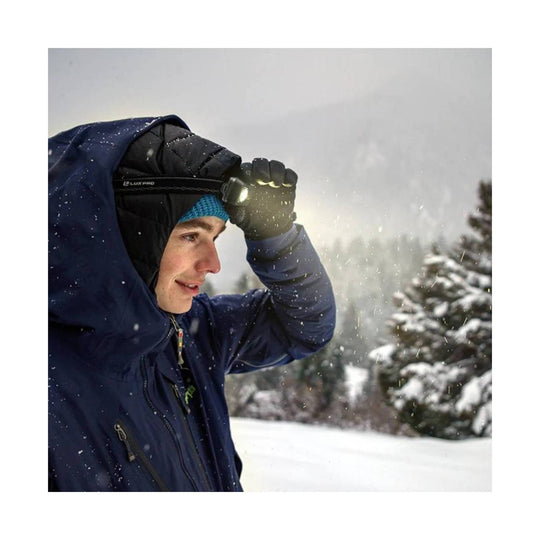 Person wearing a black headlamp in snowy outdoor conditions