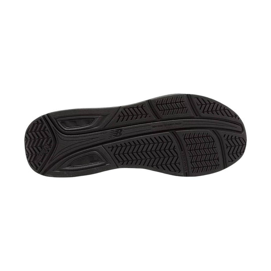 Black shoe outsole with tread patterns and New Balance logo