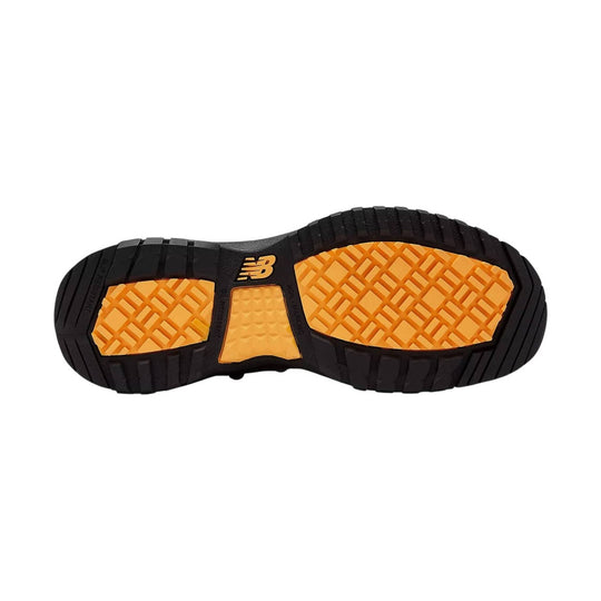 Black lugged work boot outsole with orange traction pods and NB logo