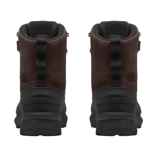Brown and black winter boots shown from the back, with tall padded collars and lug soles