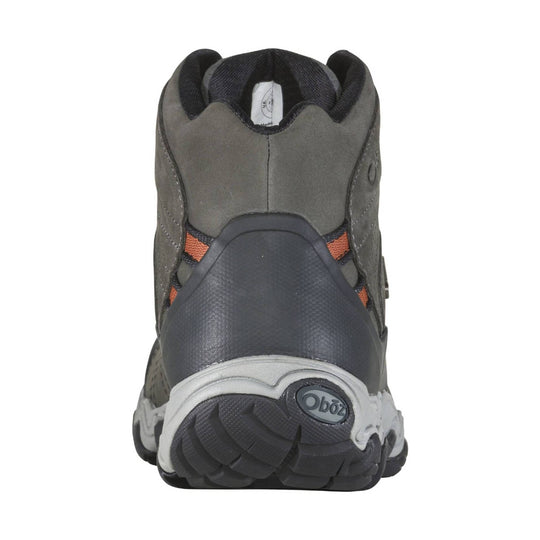 Gray mid-height hiking boot with black collar, orange side accents, and a rugged treaded sole