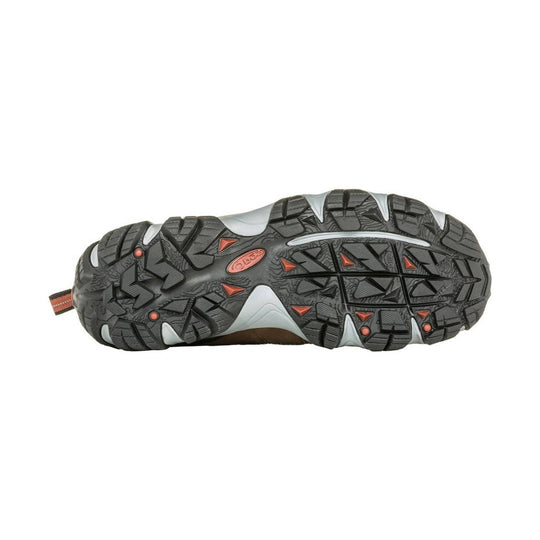 Trail shoe outsole with deep black tread and gray cushioning panels, with small orange accents.