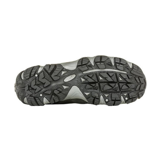 Gray and black hiking shoe outsole with deep tread and an oval logo at center
