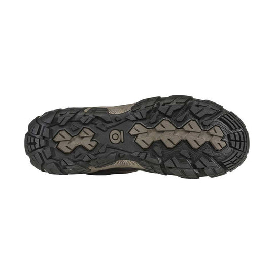 Trail shoe outsole with deep black tread and tan rubber traction pods
