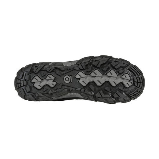 Black hiking boot outsole with aggressive multi-directional lugs and gray traction inserts