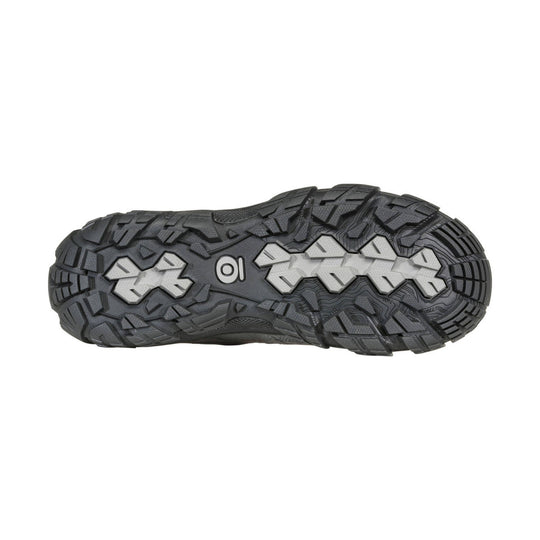 Black lugged hiking shoe outsole with light gray traction inserts and a small logo at center