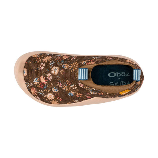 Brown floral slip-on shoe with a tan sole and blue heel tabs