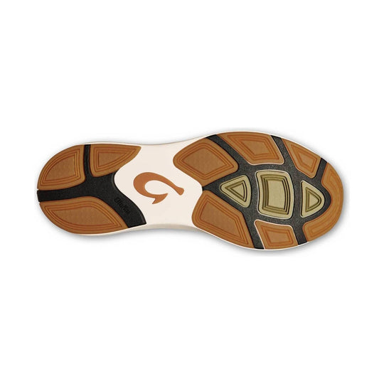 Shoe outsole with tan rubber traction pods, black sections, and a central logo mark
