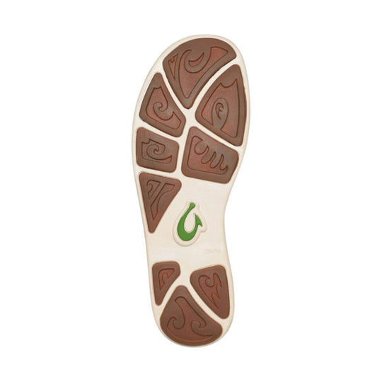 White shoe outsole with brown tread pods and a green heel logo