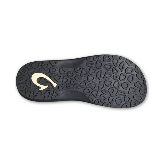Black sandal outsole with a patterned rubber tread and a cream-colored logo near the heel