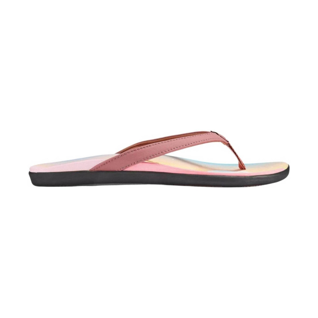 Pink flip-flop sandal with a black sole and wide thong strap, side view