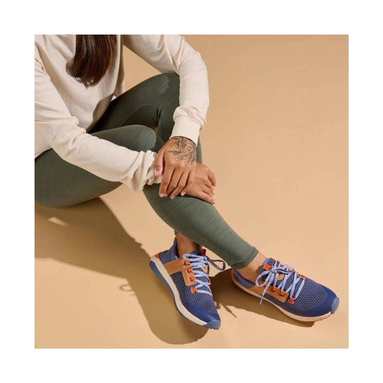 Blue mesh sneakers with tan and orange accents and light blue laces, worn with green leggings