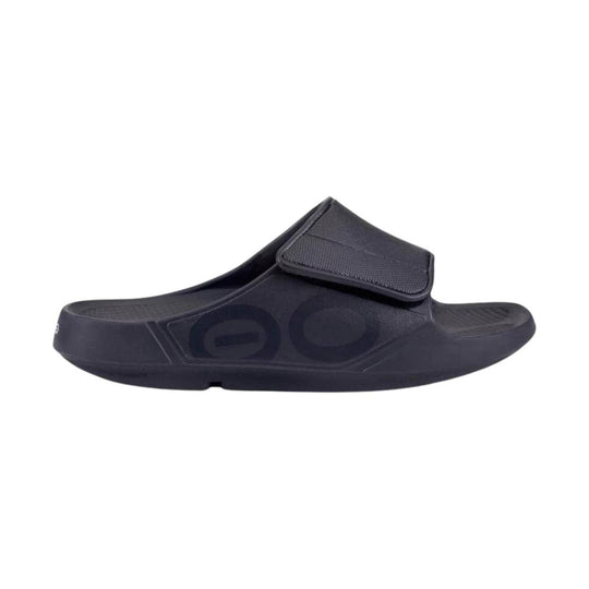 Black slide sandal with a wide top strap and contoured footbed, shown in side profile